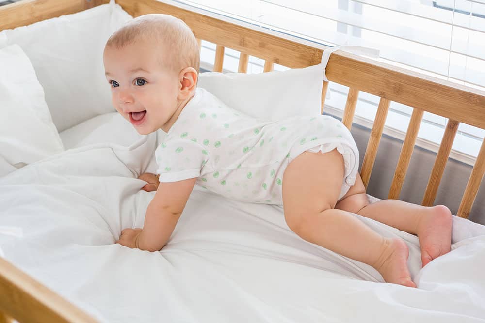 baby playing in crib