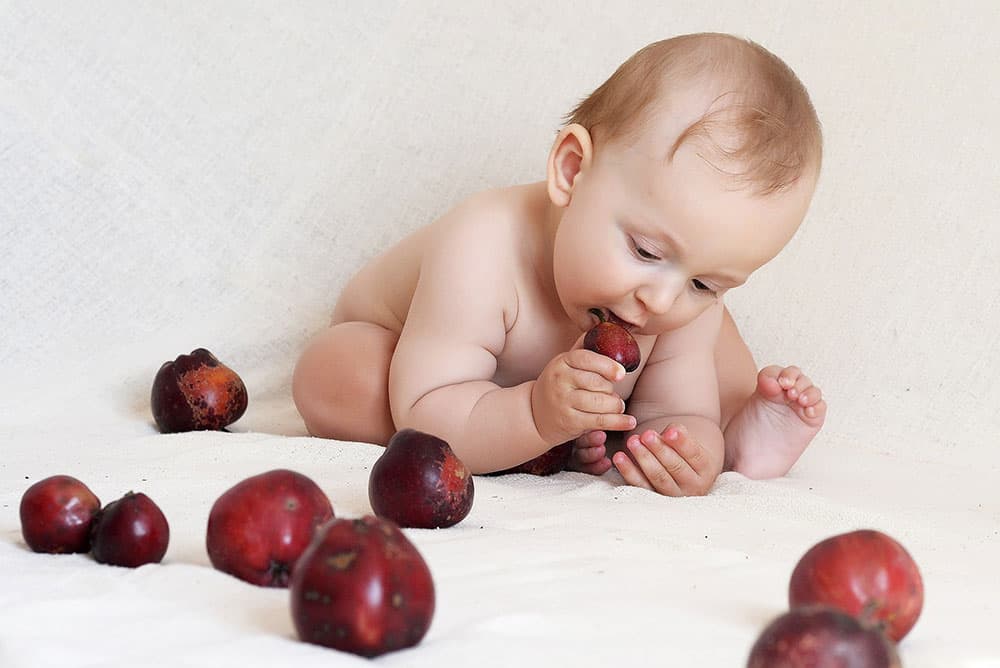 7 month old baby trying to eat plums