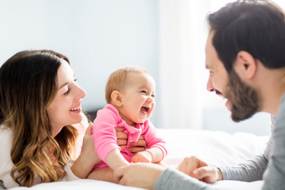 mom and dad smiling at baby