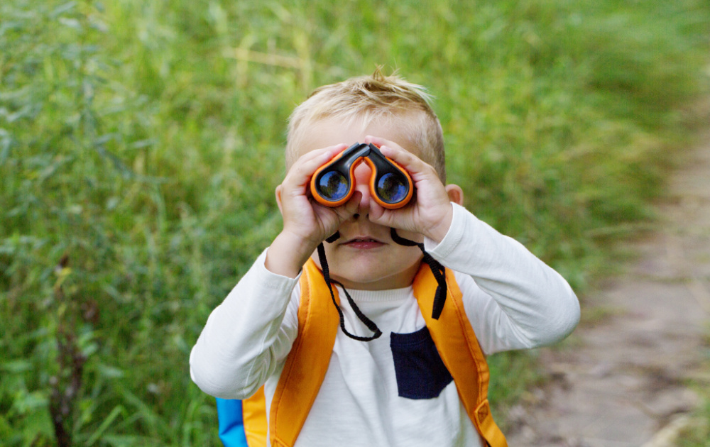 little boy looking through binoculars