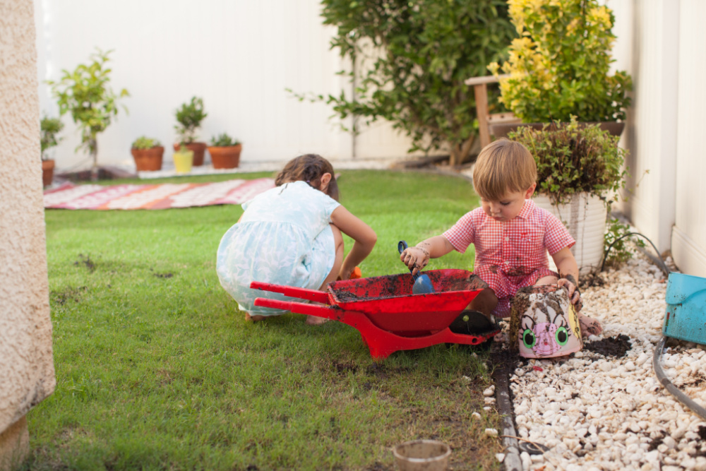 toddlers digging dirt in back yard