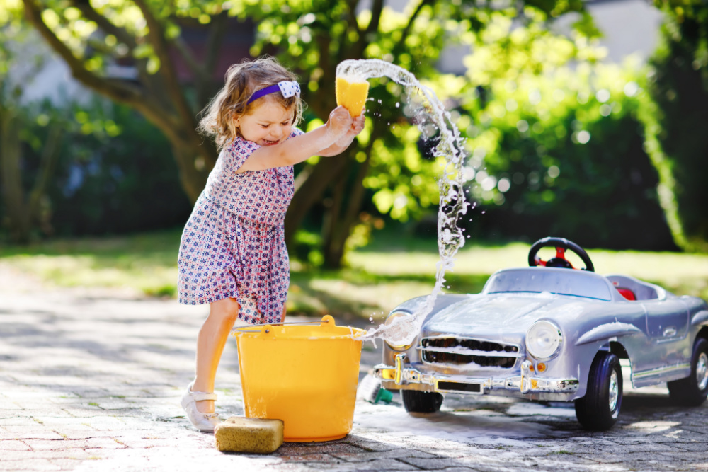 toddler washing car outside