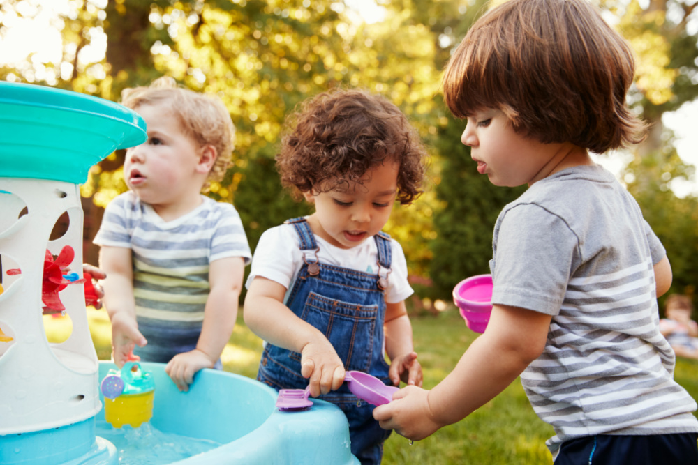 toddlers playing with a water table