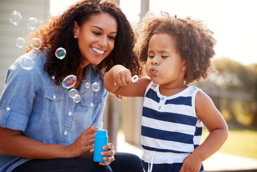 mom and toddler blowing bubbles