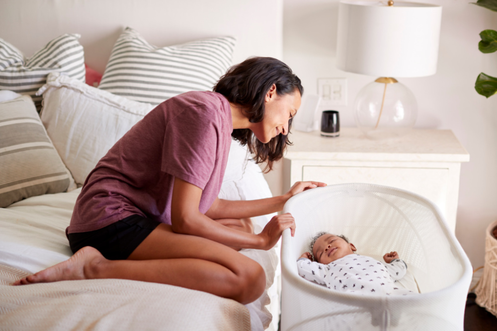 mom in bed watching over baby