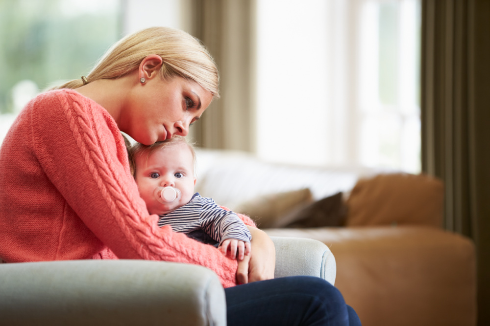 overwhelmed new mom holding baby
