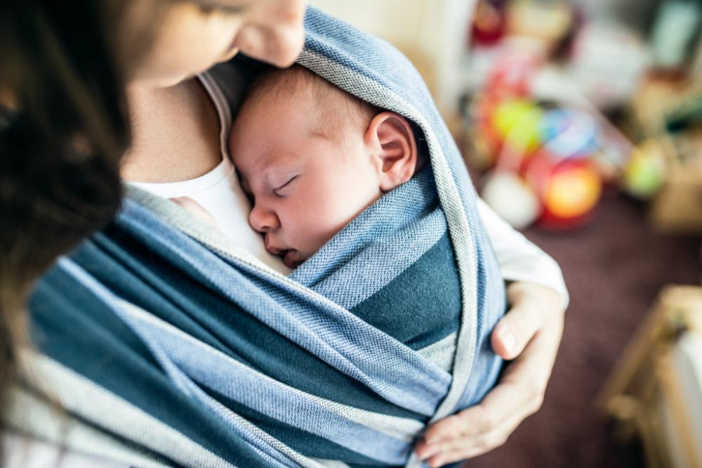 mom holding baby in carrier