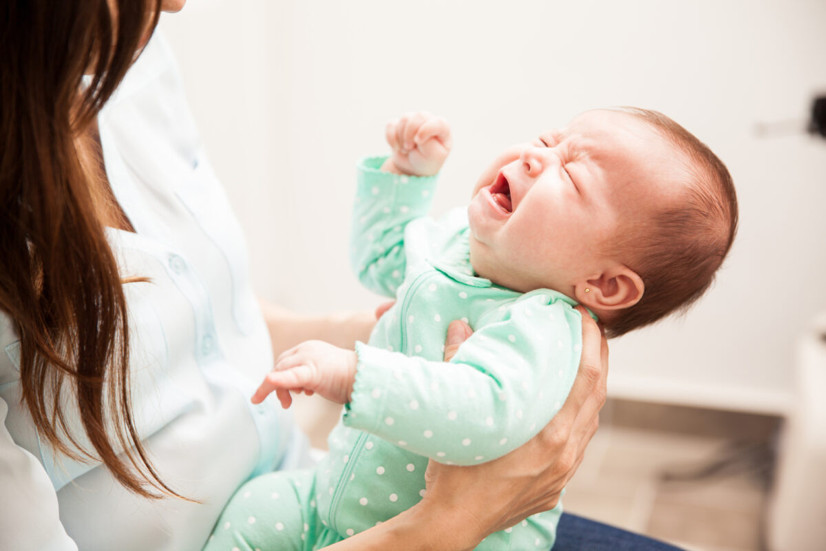 mom holding crying baby