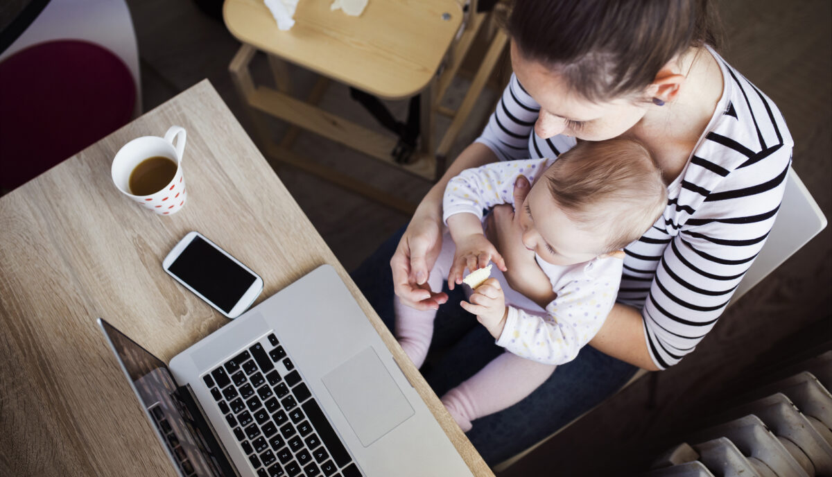 new mom working at home with a baby on her lap
