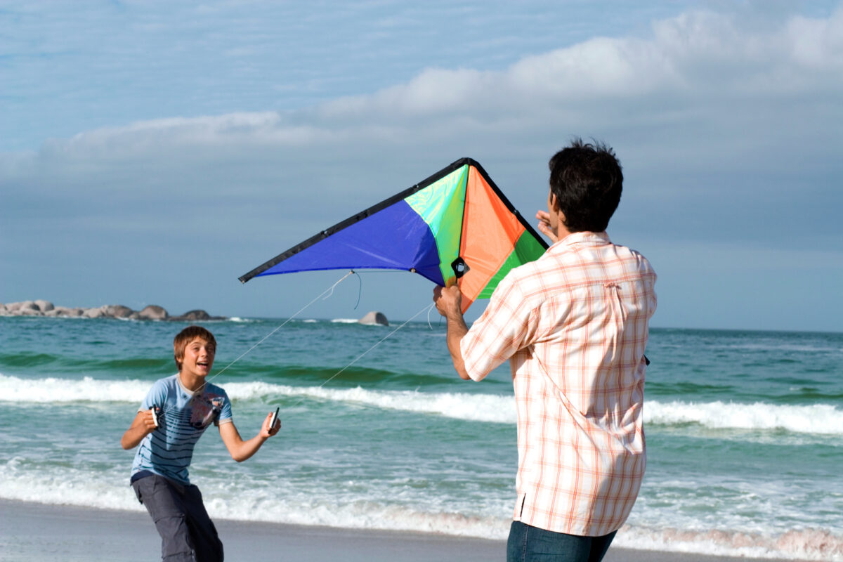 dad flying kite with son
