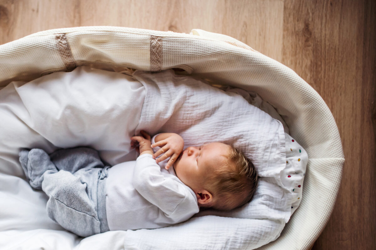 newborn sleeping in moses basket