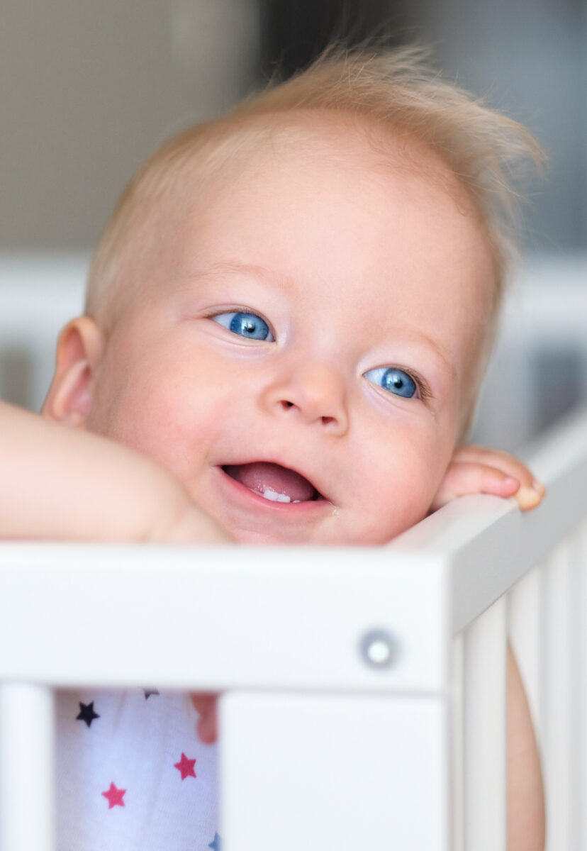 baby looking over crib
