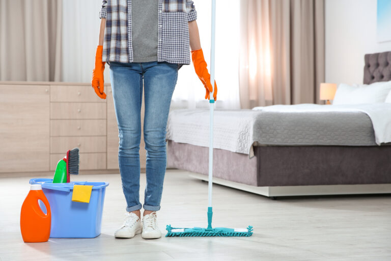 woman with cleaning supplies for cleaning bedroom