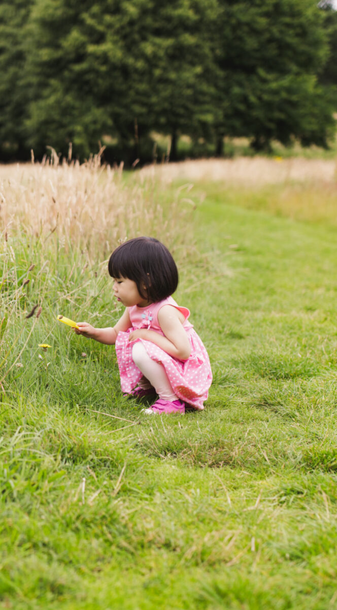 toddler looking through grass
