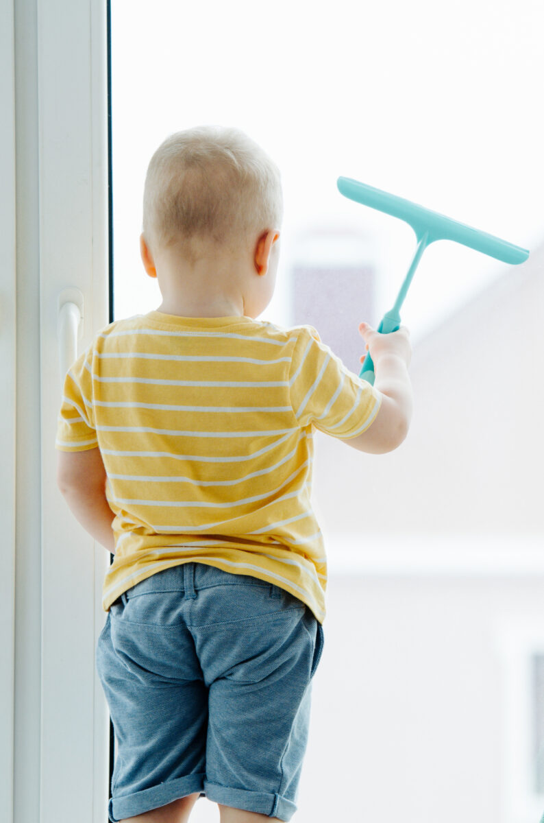 little boy cleaning window