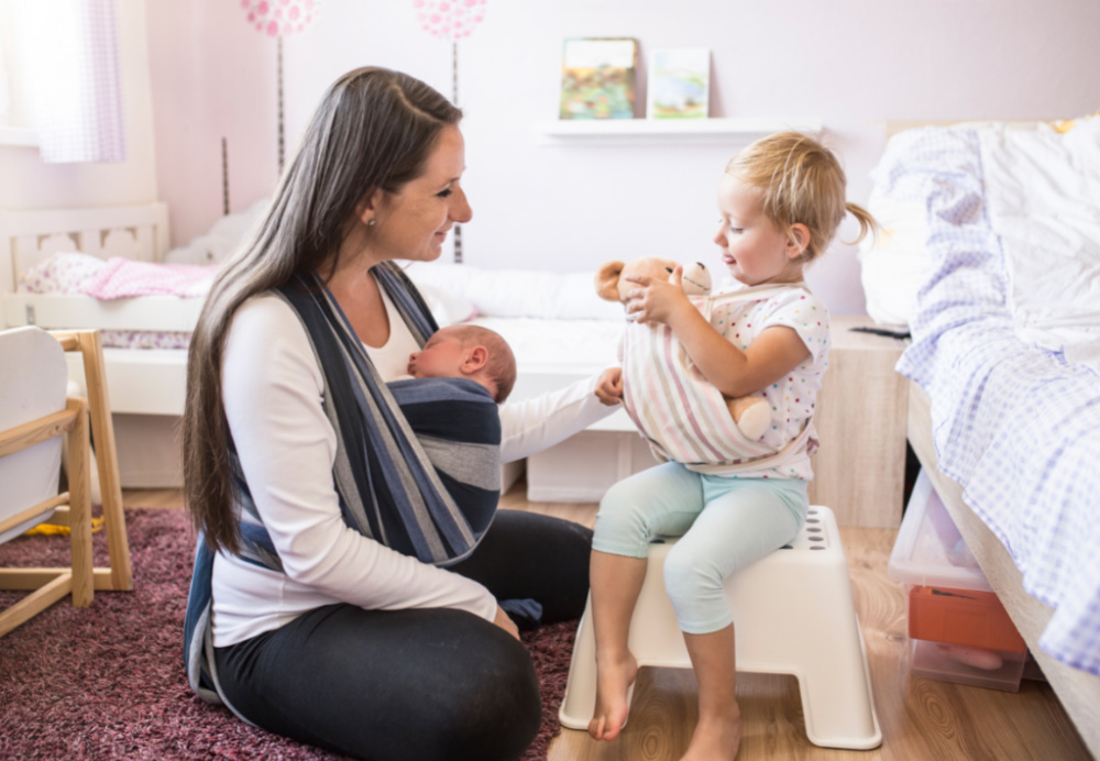 mom with two under two and baby carrier