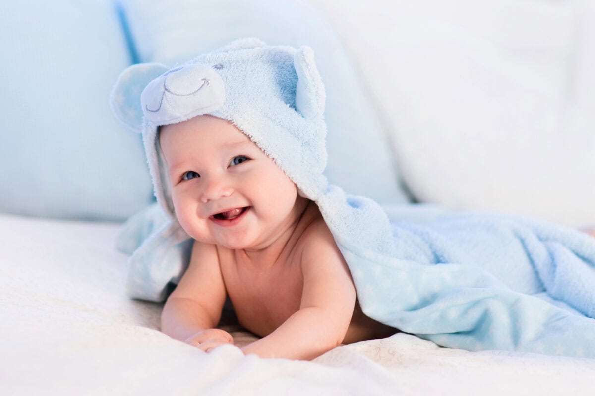 baby fresh out of bath wrapped in a fluffy blue towel