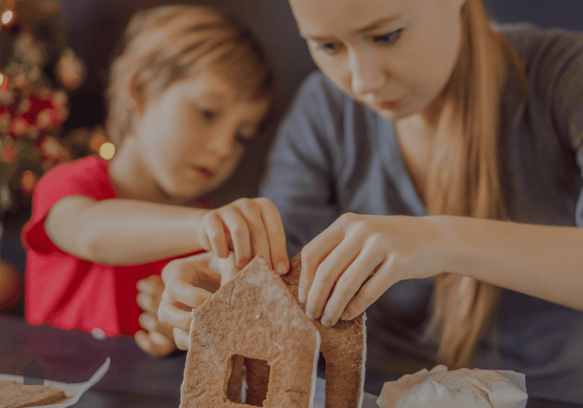 mom making gingerbread house with son