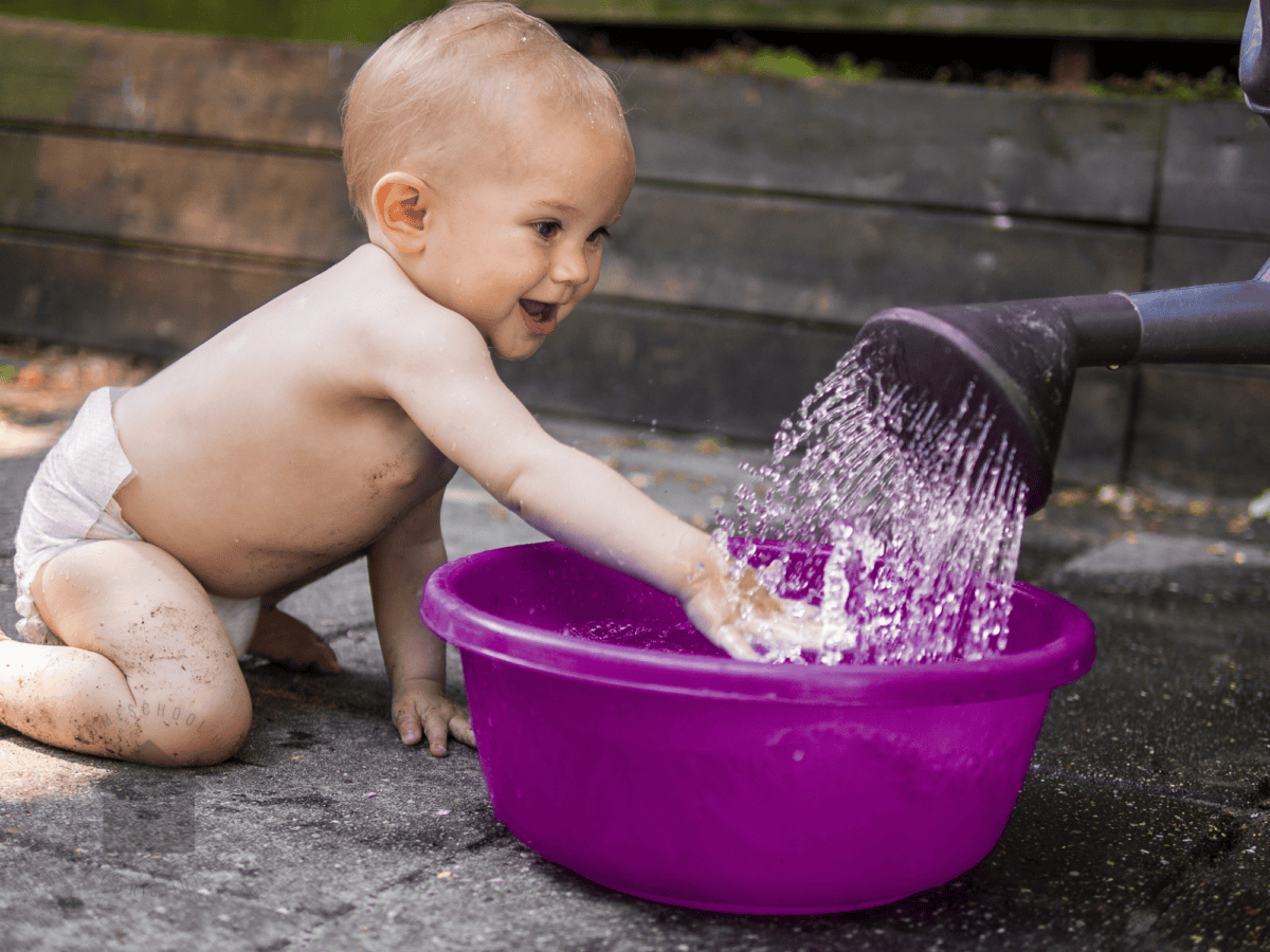 baby playing with water in a basin