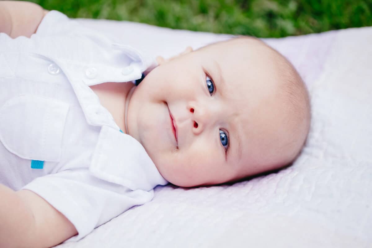 baby lying outside on blanket