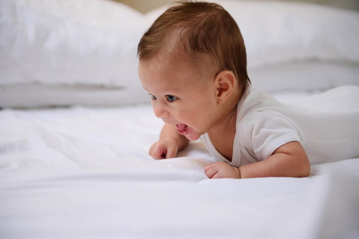 newborn lying on mattress