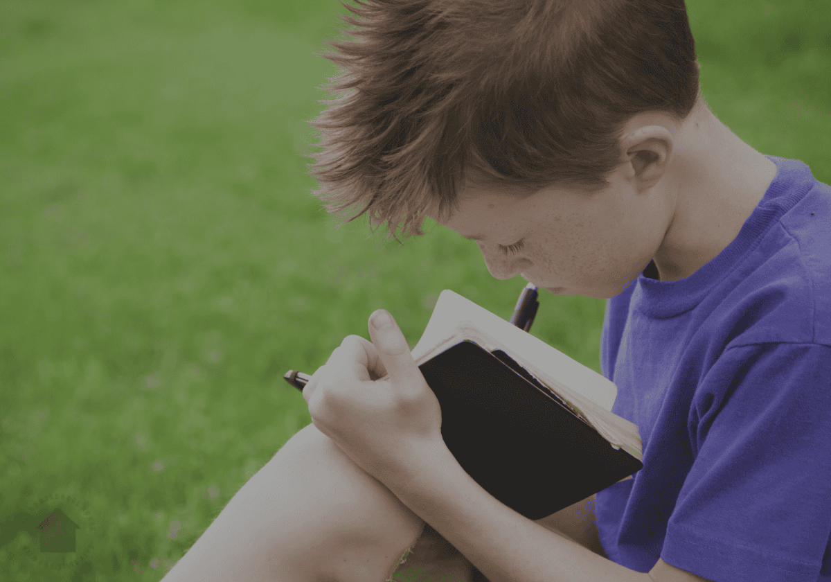 young boy nature journaling