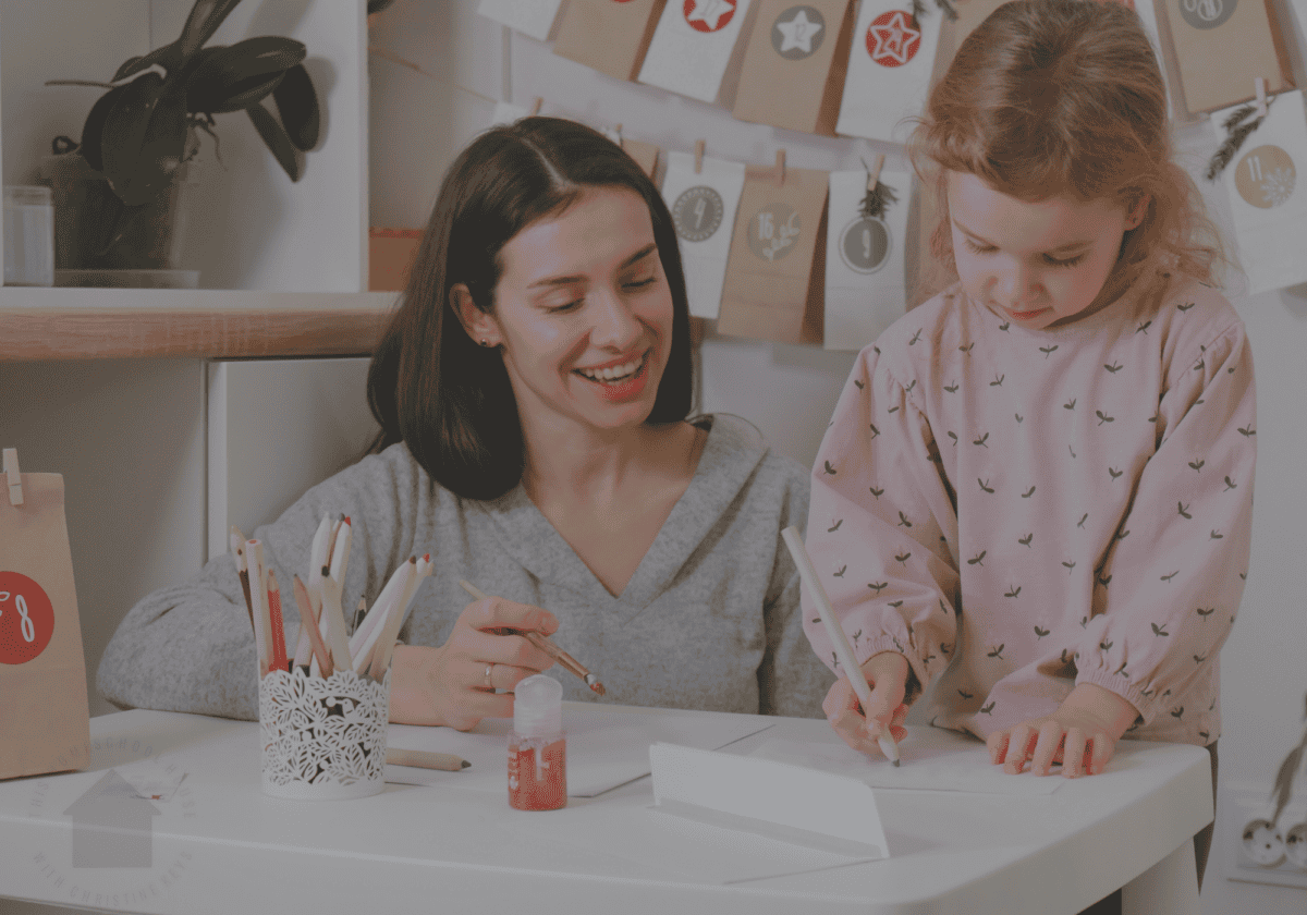 young homeschooled girl writing christmas story with mom