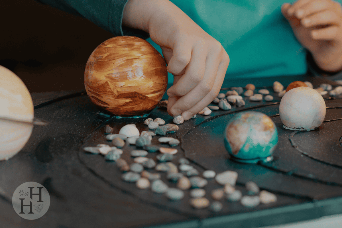 child working on solar system model