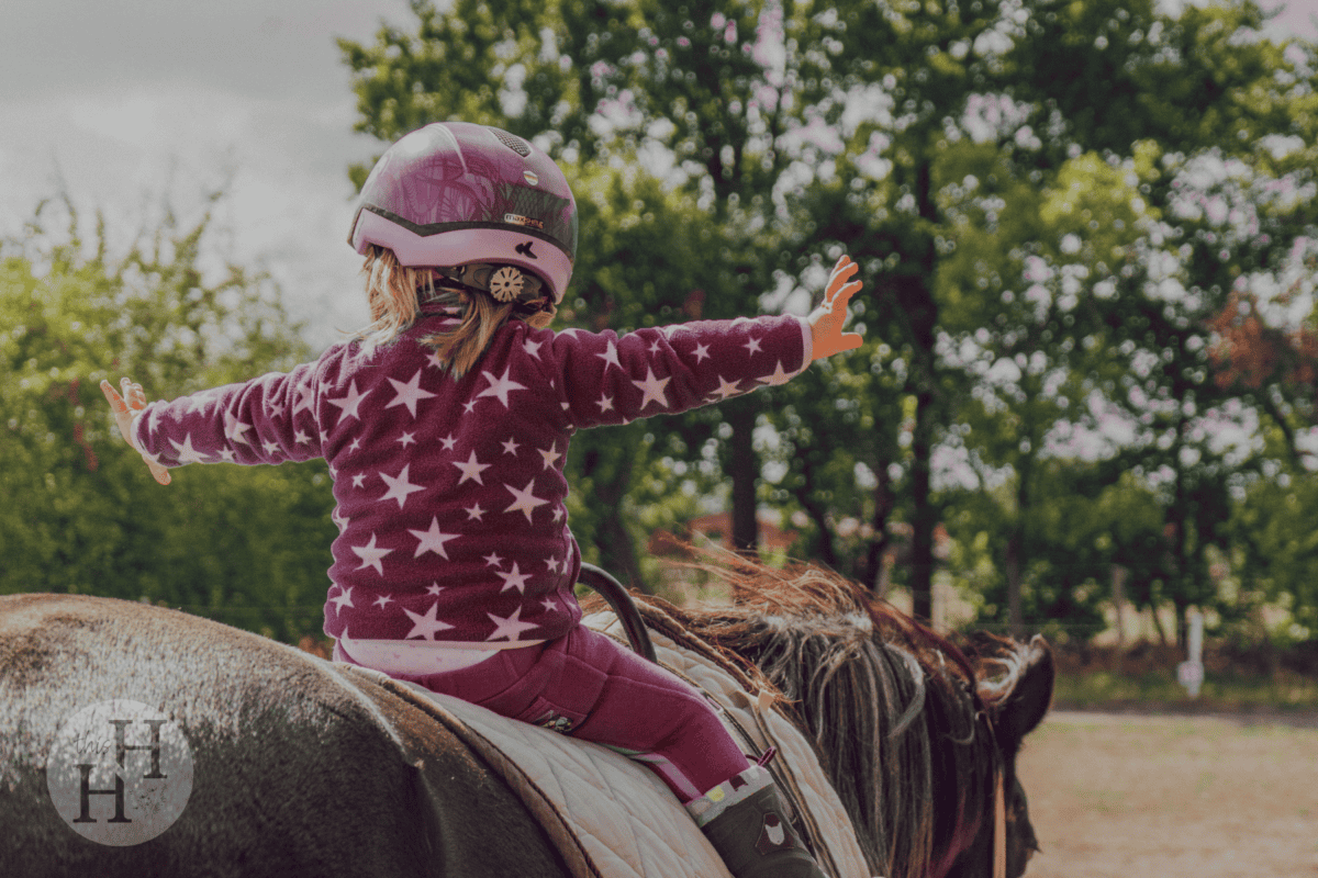 little girl courageously riding a horse