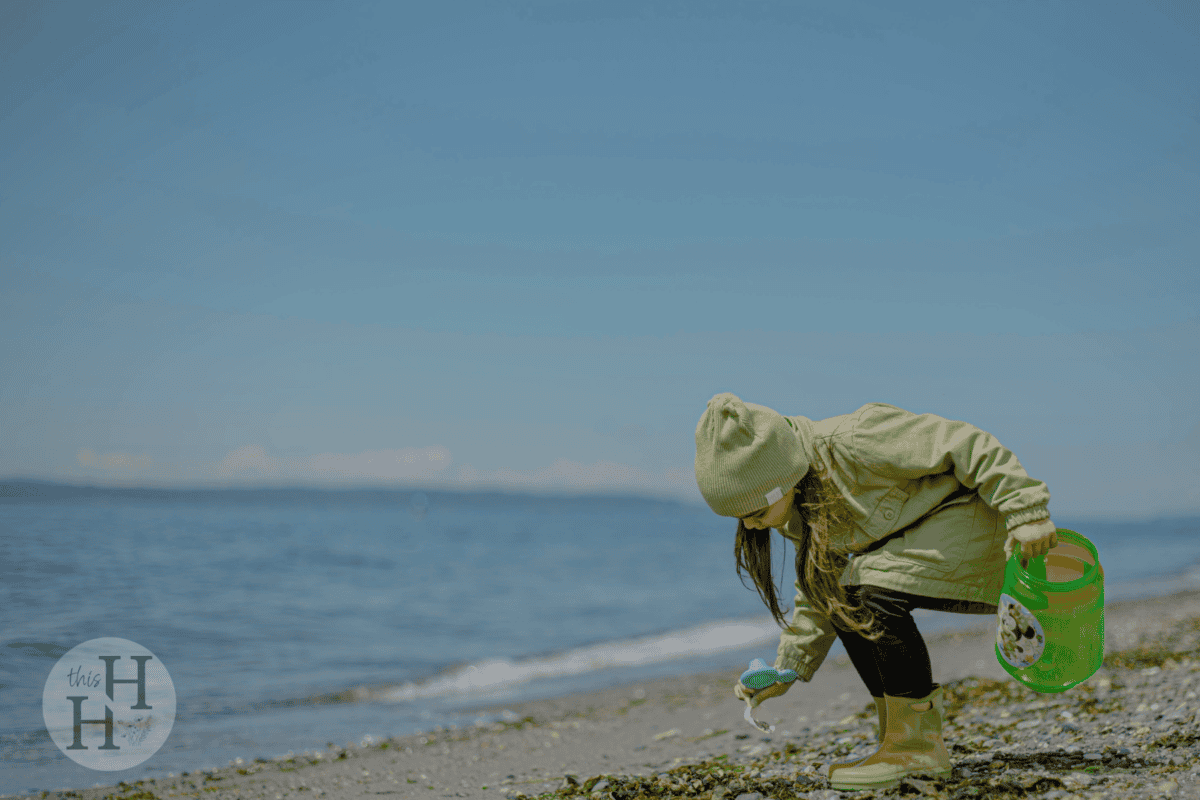 young girl collecting treasures at the beach