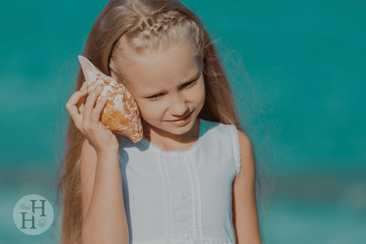 girl listening to a shell