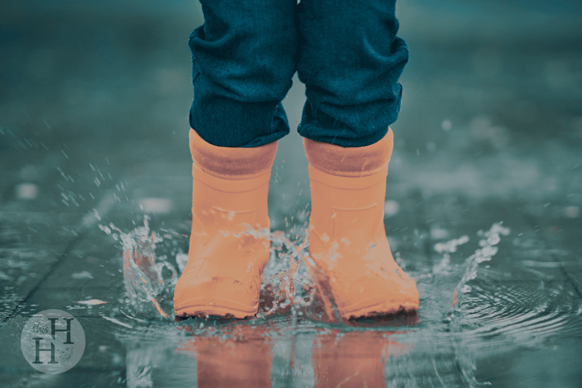 child jumping in puddles