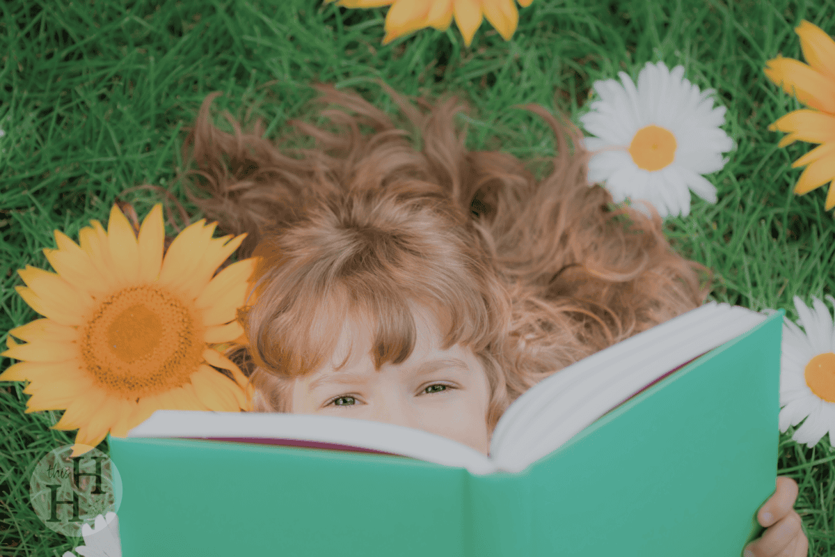 girl reading book outdoors