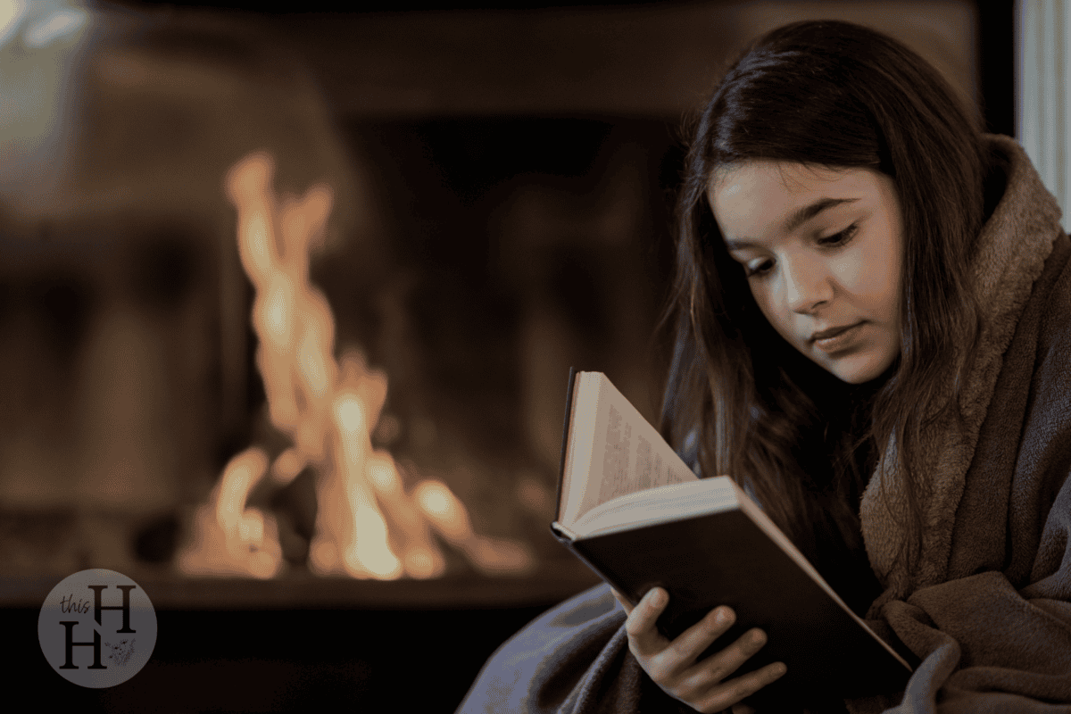 girl reading by the fire