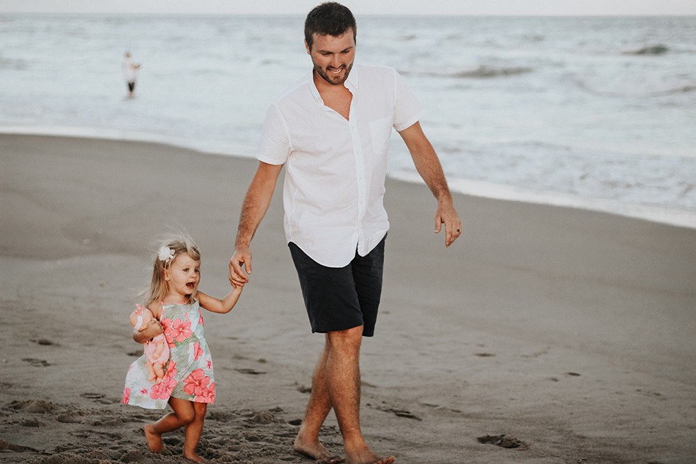 Dad walking on beach with daughter