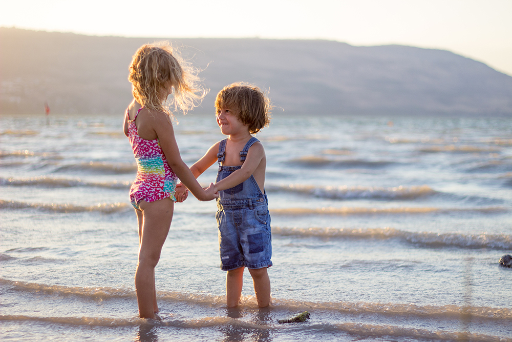 Children on beach holding hands