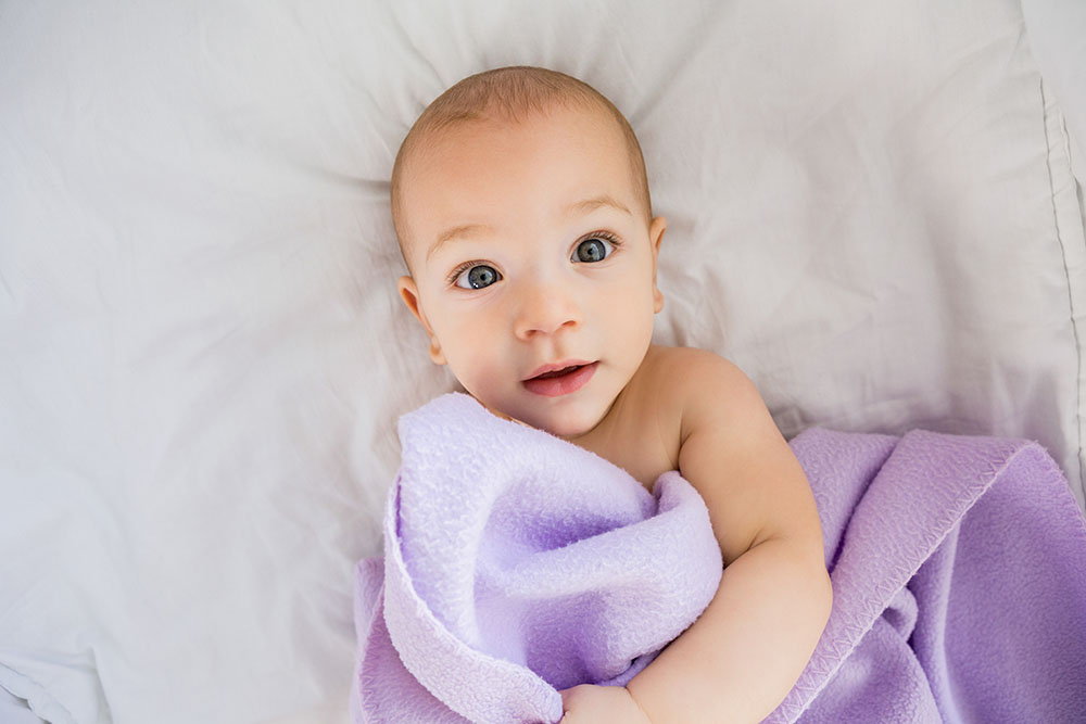 Baby under purple blanket