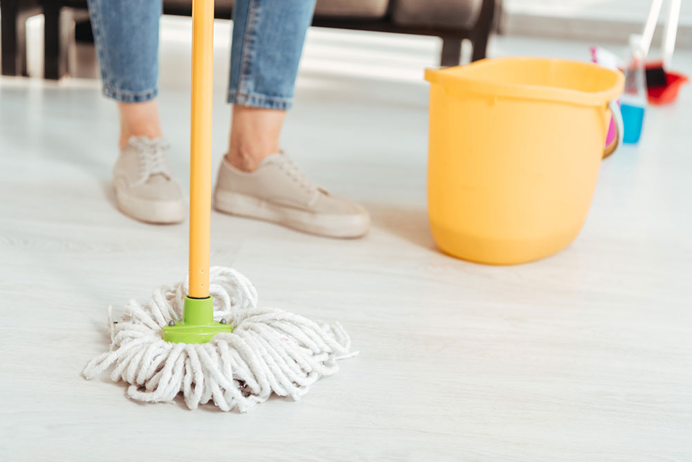 woman cleaning the floor with a mop
